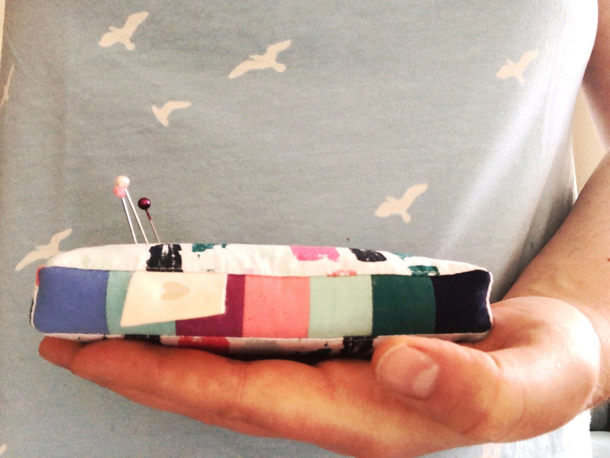 a pincushion is being held by a hand