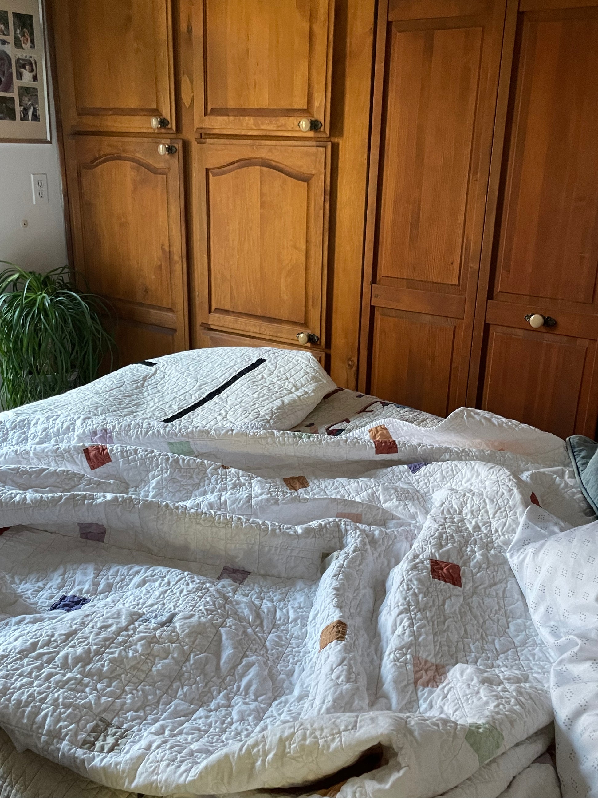 Warm White quilt on a bed with wooden wardrobes in the background